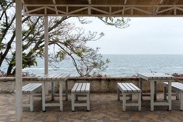 Empty tables and chairs of a restaurant on a terrace overlooking the sea. Cafe with sea view. Nice place to eat with seaview. Selective focus.