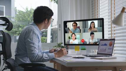 Business man talking about sale report in video conference.Asian team using laptop and tablet online meeting in video call.Working from home, Working remotely and Self isolation at home