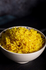 Bowl of yellow rice cooked from basmati rice with turmeric powder