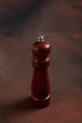 Wooden pepper shaker on dark background