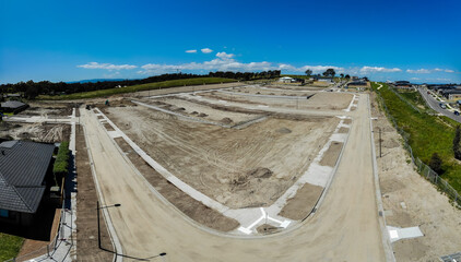 Aerial shots of a developing housing estate in the outer suburbs of Melbourne Australia, roads and gutters have been built, plots of land some already sold are almost ready for houses to be built.