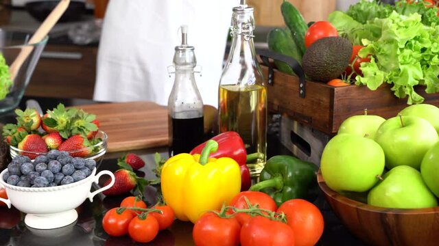 Healthy young woman in a kitchen preparing vegetables for healthy meal and salad