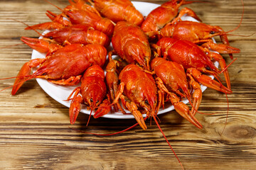 Boiled crayfish in plate on wooden table