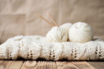 Fototapeta na wymiar light warm openwork knitted blanket and balls of yarn. knitted background. home comfort