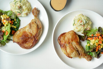 plate of delicious grilled chicken legs steak with vegetable and salad potato on white background