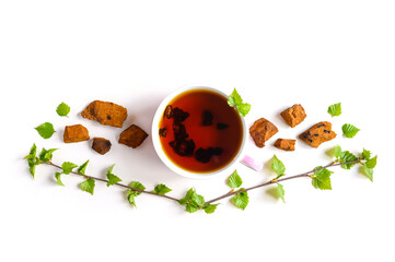 Cup of tea of birch chaga mushroom and crushed chaga fungus pieces for tea brewing isolated on a white background