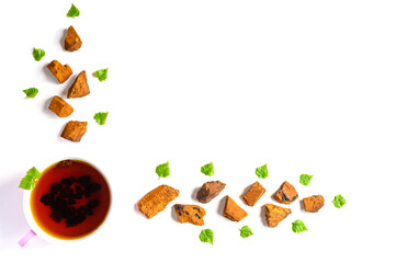 Cup of tea of birch chaga mushroom and crushed chaga fungus pieces for tea brewing isolated on a...