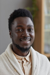 Obraz premium Portrait of African young man in white sweater smiling at camera