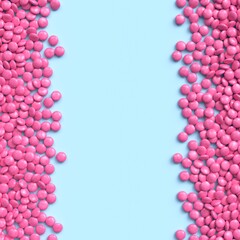 Double vertical border of pink coated chocolate candies on blue pastel background