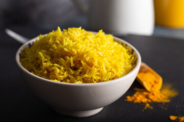 Bowl of yellow rice cooked from basmati rice with turmeric powder