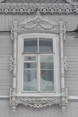Ornamental carved window, decorative frame on vintage wooden house on Pushkin Street, 34, Tomsk...