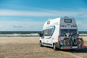 Camping Car RV standing on sand beach at waterfront on sunny day. Romo Bilstrand, Lakolk Strand, Denmark.