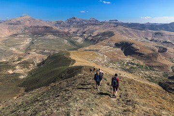 Fototapeta na wymiar Amazing wide view of a group of hikers walking down the mountain away from the camera in the Golden Gate National Park.