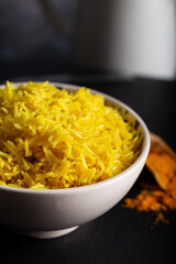 Bowl of yellow rice cooked from basmati rice with turmeric powder 