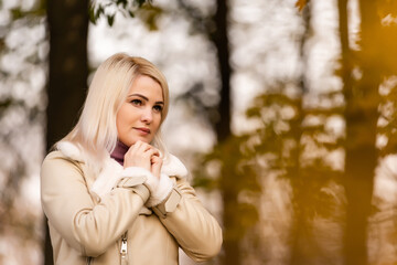 Attractive young woman is praying in the park hoping for better times to come. Concept for faith, spirituality and religion.