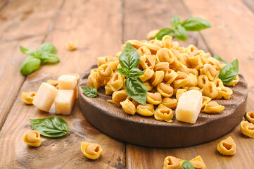 Tortellini mignon, basil with parmesan. Specialties of the cuisine from Bologna and Emilia Romagna: Cappelletti, fresh egg pasta with meat and vegetables filling. Copy space