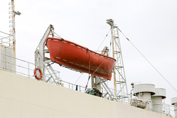 A lifeboat hangs on a sling on a cargo ship.