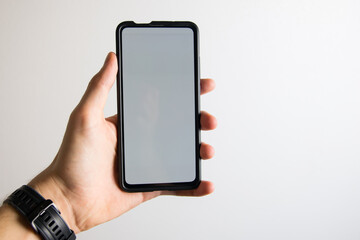 hand holding a smartphone with white screen on a white background