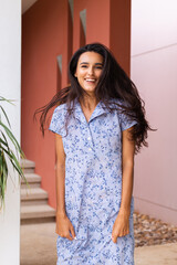Fototapeta premium Cute smile pretty caucasian woman in blue dress on background of brown wall 