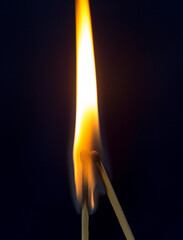 two matchstick lit on black background