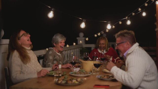 Happy senior friends having fun dining together on house patio - Food and elderly people lifestyle concept