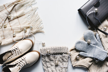 winter fashion set of woman clothes in neutral tones: warm sweater, hat, mittens, shoes and handbag...