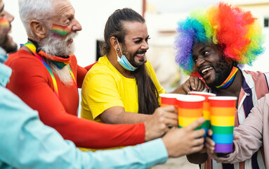 Happy multiracial people cheering and drinking cocktails in gay pride festival event