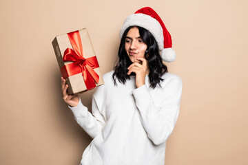 Christmas, x-mas, winter, happiness concept. Smiling woman in santa helper hat with many gift boxes isolated on beige background