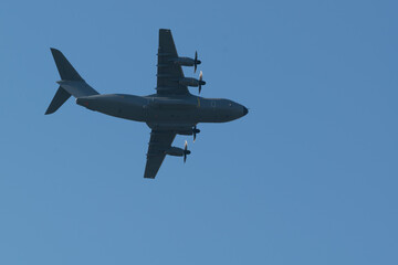 Avion de transport militaire Airbus A400M de démonstration en vol en vue de dessous sur un fond de ciel bleu au dessus de St Nazaire