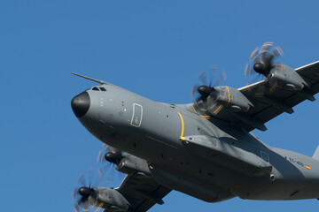 Fototapeta na wymiar Avion de transport militaire Airbus A400M de démonstration en vol en vue de face sur un fond de ciel bleu au dessus de St Nazaire