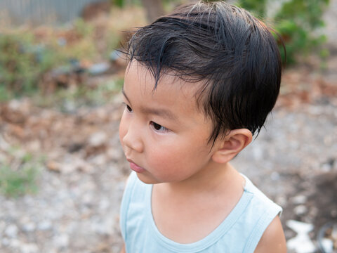 Asian cute child boy face with sweat on hair while playing outdoor. Childhood happiness activity in summer.