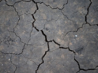 Surface of a grungy dry cracking parched earth for textural background.