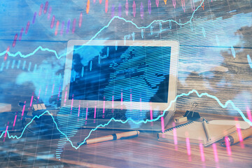 Double exposure of chart and financial info and work space with computer background. Concept of international online trading.