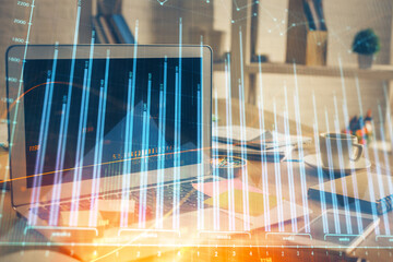 Financial chart drawing and table with computer on background. Double exposure. Concept of...