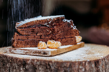 chocolate cake on a wooden bord sprinkled with sugar powder