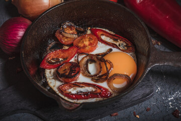 Cast-iron skillet: eggs, tomatoes and fried meat