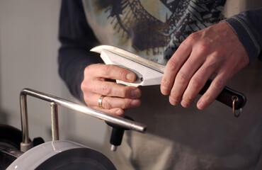Knife sharpener and hand with blade