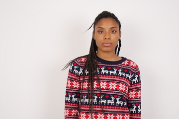 Joyful Young beautiful African American woman wearing Christmas sweater against white wall, ...