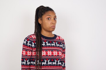 Young beautiful African American woman wearing Christmas sweater against  with snobbish expression...