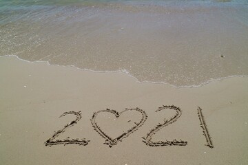 Happy New year 2021 with the waves beat at the beach and shell fragments. Soft focus. Holiday and nature concept.