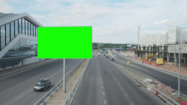  Empty billboard with a green screen for advertising, on a highway, blank billboard at city on roadside against cars