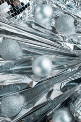 Happy New Year and Merry Christmas Festive background with silver balls on a shiny foil.