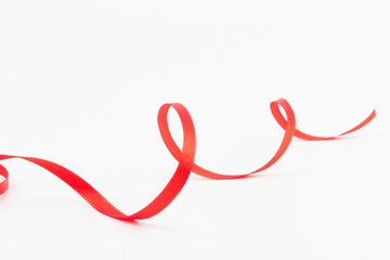 Top view of Red ribbon isolated shiny rolled on white background. Flat lay view.