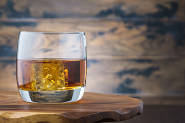 Golden whiskey or bourbon with ice cubes in glass