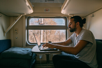 Man with laptop on the train.