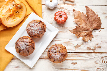 Plate with tasty pumpkin muffins on table