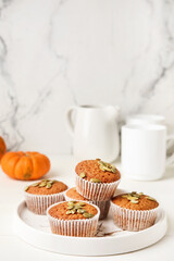 Plate with tasty pumpkin muffins on table