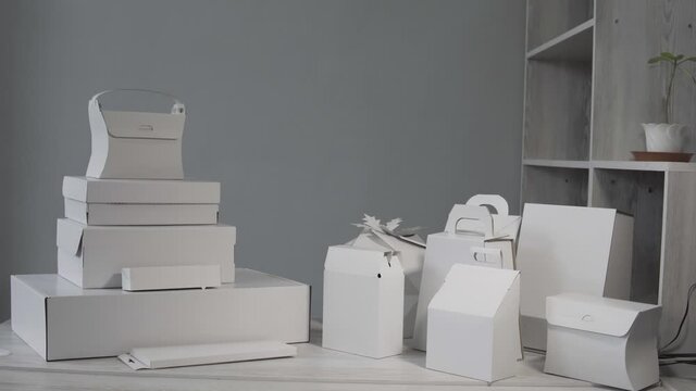 Different design and shape of cardboard boxes, paper containers. The concept of production and development of packaging. Industry