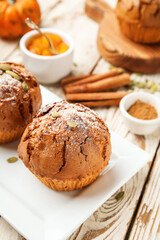 Fototapeta na wymiar Plate with tasty pumpkin muffins on table, closeup