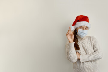 Fototapeta na wymiar Young woman wearing protection mask for coronavirus disease over beige background smiling cheerful pointing with hand and finger up to the side